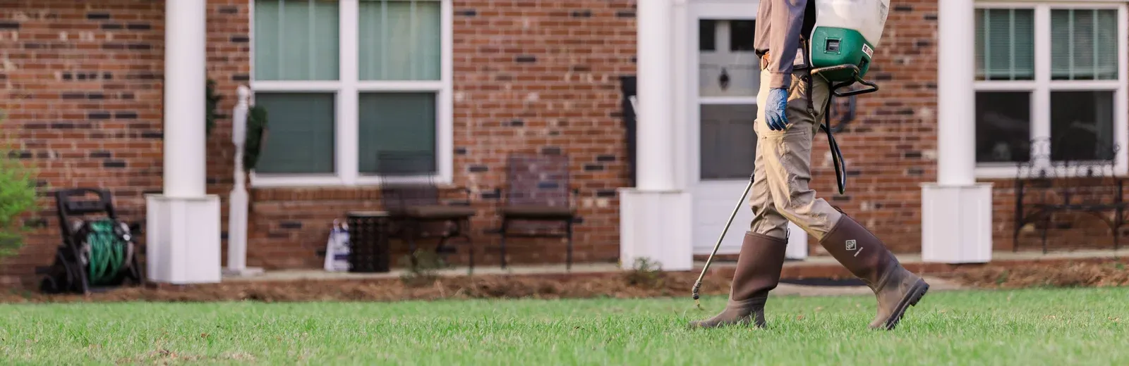 technician spraying weeds in lawn